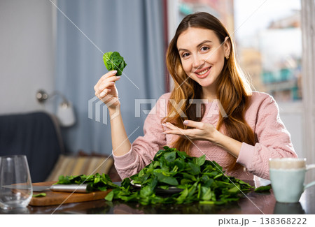 Young woman sorts fresh spinach Young woman sorts fresh spinach 138368222