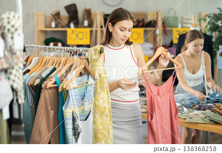 woman chooses a cotton dress against the background of a buyer 138368258