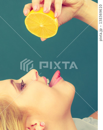 Girl drinking juice from juicy lemon fruit 138369610