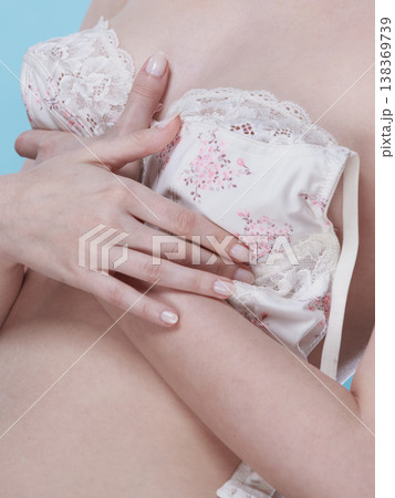 Naked woman dressing up her bra. 138369739