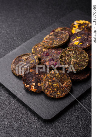 Organic Chinese green pu-erh tea with various herbs in round bricks. Chinese pu-erh tea Organic Chinese green pu-erh tea with various herbs in round bricks. Chinese pu-erh tea 138370069