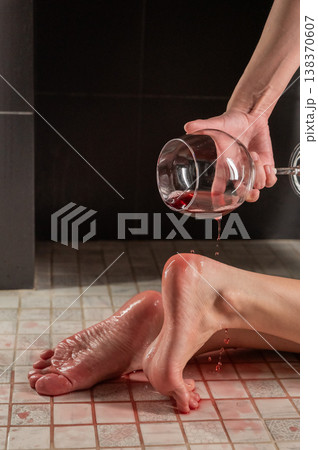 Foot fetish. A woman pours wine from a glass onto her feet in the shower. 138370607