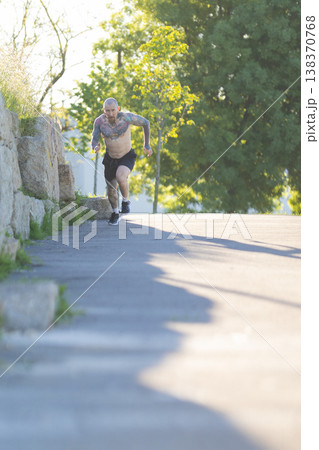 Athletic man running uphill during outdoor training Athletic man running uphill during outdoor training 138370768