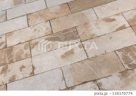 A close-up of aged beige stone tiles laid in a rectangular pattern A close-up of aged beige stone tiles laid in a rectangular pattern 138370774