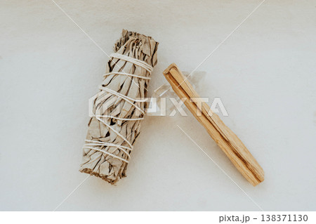 White sage bundle, palo santo stick and clear quartz crystal on light background 138371130