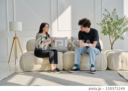 Young male patient in therapy session talking with female psychotherapist Young male patient in therapy session talking with female psychotherapist 138371249
