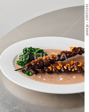 Gourmet skewers arranged with wilted greens and shiny sauce Gourmet skewers arranged with wilted greens and shiny sauce 138372242