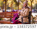 Happy woman with eating disorders using smartphone sitting on park bench 138372597