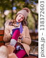 Woman writing thoughts in diary sitting on park bench. Eating disorder 138372603