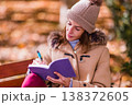 Woman writing personal diary for mental health support outdoors 138372605