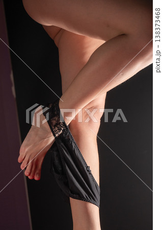 Foot fetish. A woman takes off her black lace panties. Foot fetish. A woman takes off her black lace panties. 138373468