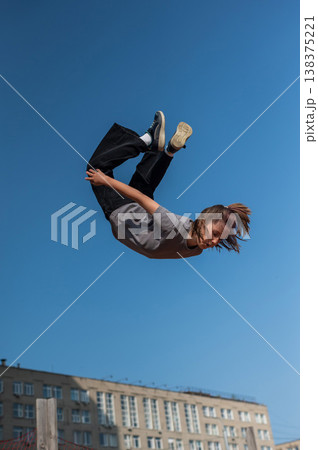 A girl jumps on an outdoor trampoline. 138375221