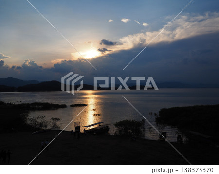 Serene lake sunset, golden sky, calm water, distant mountain, peaceful landscape, dramatic cloud reflection Serene lake sunset, golden sky, calm water, distant mountain, peaceful landscape, dramatic cloud reflection 138375370