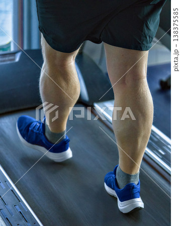 Intense Gym Session With Focused Calf Muscles Moving Rhythmically On Treadmill 138375585