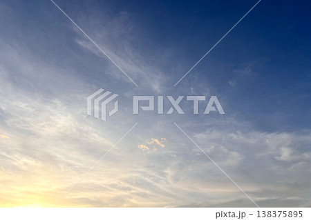 朝焼けの光に染まる淡い空と流れる雲 138375895