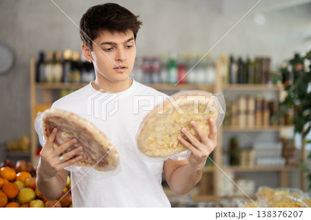 European guy looks at product and shop around, choose and buy pizza with different filling in shop European guy looks at product and shop around, choose and buy pizza with different filling in shop 138376207