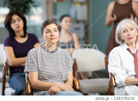 Middle-aged woman sitting on chair and listening to presentation Middle-aged woman sitting on chair and listening to presentation 138376210