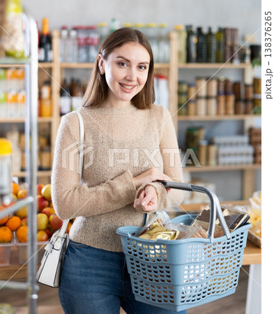 Visiting store, girl is looking at something on shelf of showcase. Visiting store, girl is looking at something on shelf of showcase. 138376265
