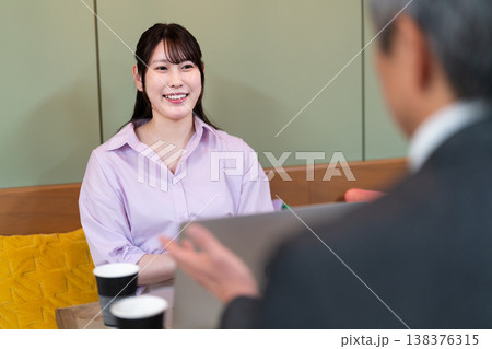 カフェでパソコンを使いながら打ち合わせをする男女 138376315