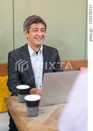 カフェでパソコンを使いながら打ち合わせをする男女 138376317