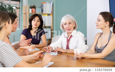 Group of women solving problems sitting around the table 138376609