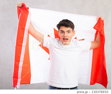 Surprised young guy holding Canada flag 138376650