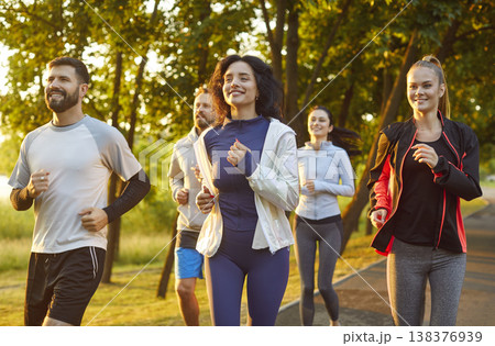 Group of sporty friends people running, jogging outdoors in sunny park, moving together smiling 138376939