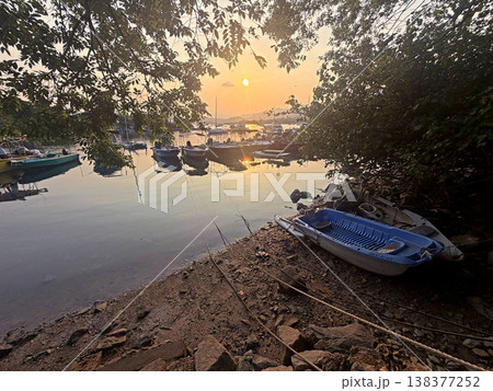 Boats moored at a tranquil harbor during a serene golden hour sunset Boats moored at a tranquil harbor during a serene golden hour sunset 138377252
