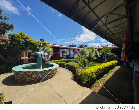 Courtyard with fountain and plants in sunny outdoor setting 138377433