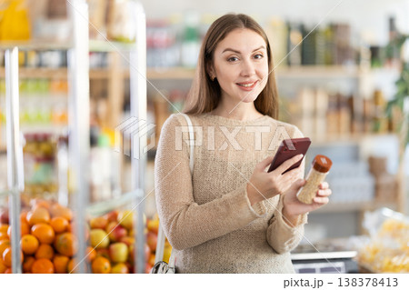 Young woman scanning qr code for seasoning herbs Young woman scanning qr code for seasoning herbs 138378413