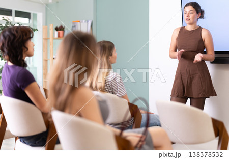 Young woman speaks to audience of listeners, carry out lecture. 138378532