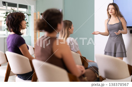 Young woman speaks to audience of listeners, carry out lecture. Young woman speaks to audience of listeners, carry out lecture. 138378567