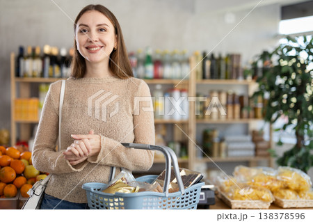 Visiting store, girl is looking at something on shelf of showcase. Visiting store, girl is looking at something on shelf of showcase. 138378596