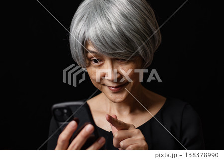スマートフォンを操作する白髪のシニア女性 138378990