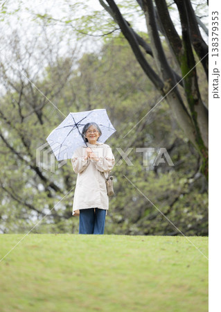 傘をさして梅雨や雨を楽しむ散歩する高齢女性の穏やかで健康的なアクティブシニア 全身 傘をさして梅雨や雨を楽しむ散歩する高齢女性の穏やかで健康的なアクティブシニア 全身 138379353