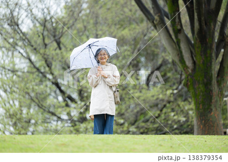 傘をさして梅雨や雨を楽しむ散歩する高齢女性の穏やかで健康的なアクティブシニア 全身 傘をさして梅雨や雨を楽しむ散歩する高齢女性の穏やかで健康的なアクティブシニア 全身 138379354