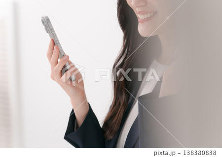 スマホを操作するスーツの女性 138380838