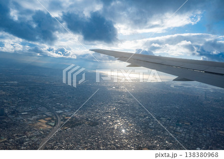 飛行機の窓から見える大阪の景色、太陽が眩しい 138380968