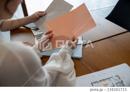 壁紙サンプルを持って相談する若いカップルの手元 壁紙サンプルを持って相談する若いカップルの手元 138381715