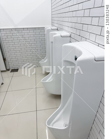 清潔な白い男性用トイレの小便器が並ぶ室内空間 清潔な白い男性用トイレの小便器が並ぶ室内空間 138383248