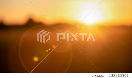Blurred abstract beautiful colorful bright landscape background showing warm golden sun rays shining through natural evening sky creating soft light flares and peaceful atmosphere 138383501