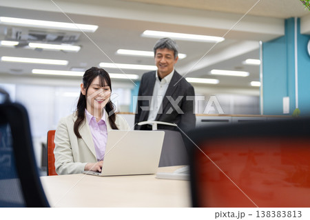 仕事の相談やアドバイスをするオフィスのビジネスマンと女性 仕事の相談やアドバイスをするオフィスのビジネスマンと女性 138383813