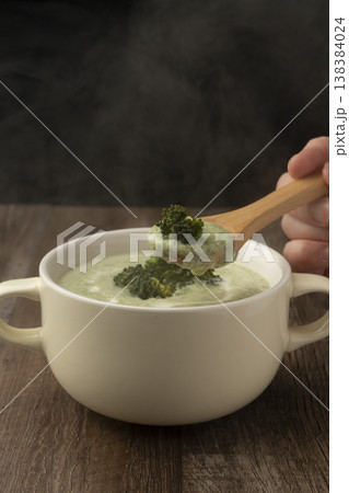 湯気の立ったブロッコリーのポタージュをスプーンで持ち上げる 138384024