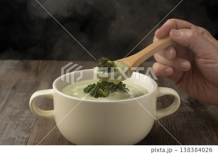 湯気の立ったブロッコリーのポタージュをスプーンで持ち上げる 湯気の立ったブロッコリーのポタージュをスプーンで持ち上げる 138384026