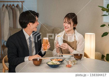 マイホームのダイニングテーブルで食事,晩酌をする若いアジア人夫婦,カップル(ビール,缶ビール) マイホームのダイニングテーブルで食事,晩酌をする若いアジア人夫婦,カップル(ビール,缶ビール) 138384417