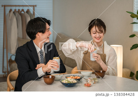 マイホームのダイニングテーブルで食事,晩酌をする若いアジア人夫婦,カップル（ビール,缶ビール） 138384428