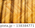 Warm oak parquet flooring with diagonal sunlight casting shadows across the surface 138384771
