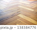 Close-up view of a warm toned wooden parquet floor with a herringbone pattern 138384776