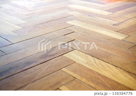 Close-up view of a warm toned wooden parquet floor with a herringbone pattern Close-up view of a warm toned wooden parquet floor with a herringbone pattern 138384776