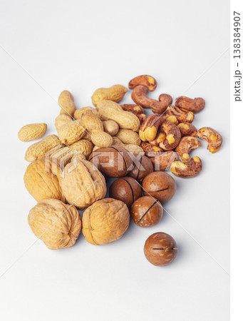 Assortment of nuts with nutshells, walnuts, macadamia, cashew and peanuts on white background Assortment of nuts with nutshells, walnuts, macadamia, cashew and peanuts on white background 138384907